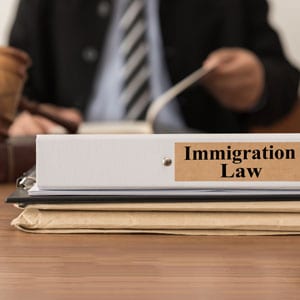 A desk displays a binder marked 'Immigration Law', highlighting the importance of legal frameworks 